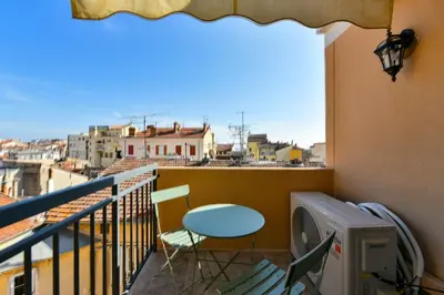 a balcony with a table and chairs and a view at L'ALIZEE avec jolie terrasse vue sur la ville, charmant studio dans le centre de Cannes in Cannes