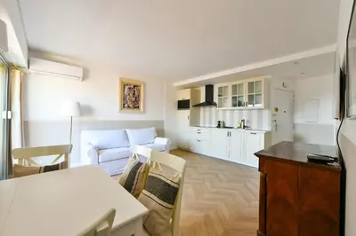 a kitchen and living room with a couch and a table at L'ALIZEE avec jolie terrasse vue sur la ville, charmant studio dans le centre de Cannes in Cannes