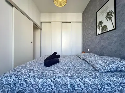 a blue bed with a teddy bear laying on it at Andréa By SCLS Locations in Cannes