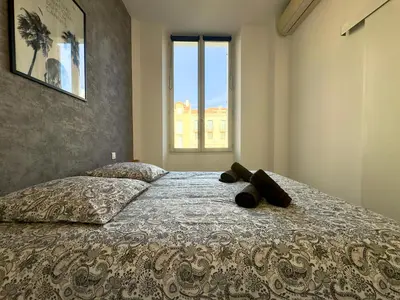 a bedroom with a bed with a large window at Andréa By SCLS Locations in Cannes