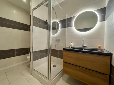 a bathroom with a shower and a sink and a mirror at Andréa By SCLS Locations in Cannes