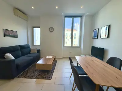 a living room with a couch and a table at Andréa By SCLS Locations in Cannes