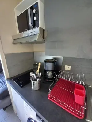 a kitchen with a counter top with a red drying rack at appartement les pieds dans l'eau in Cannes