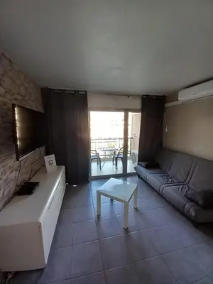 a living room with a couch and a table at appartement les pieds dans l'eau in Cannes