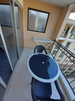a table and chairs in a balcony with a window at appartement les pieds dans l'eau in Cannes