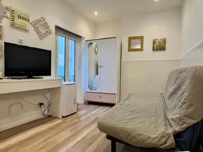 a living room with a tv and a chair in a room at Mini Studio - Le Chevalier By SCLS Locations in Cannes