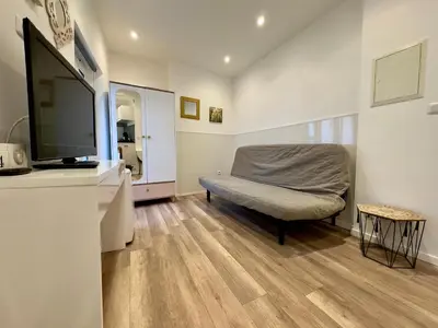 a living room with a couch and a flat screen tv at Mini Studio - Le Chevalier By SCLS Locations in Cannes
