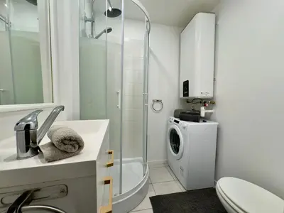 a bathroom with a shower and a washing machine at Mini Studio - Le Chevalier By SCLS Locations in Cannes
