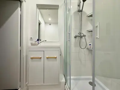 a white bathroom with a shower and a sink at Mini Studio - Le Chevalier By SCLS Locations in Cannes