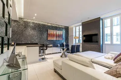 a living room with a white couch and a table at Large renovated studio - rue Hoche - Cannes center in Cannes