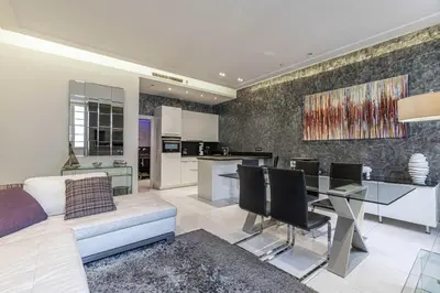 a living room and kitchen with a couch and a table at Large renovated studio - rue Hoche - Cannes center in Cannes