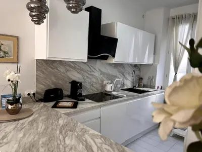 a white kitchen with a sink and white cabinets at One Bedroom apartment in Cannes Center a few steps from the Croisette and the Martinez Hotel - 2032 in Cannes