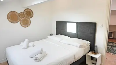 a bedroom with a white bed with a black headboard at Proche Carlton & Croisette, Appartement 401 - Palmazur Vacances in Cannes