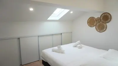 a white bedroom with a bed and a skylight at Proche Carlton & Croisette, Appartement 401 - Palmazur Vacances in Cannes
