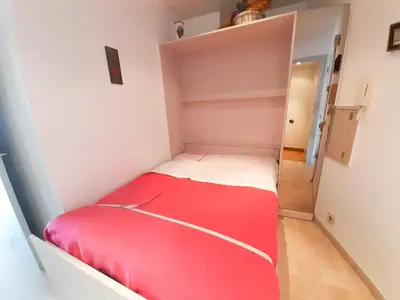 a small bedroom with a red bed in a room at Trident A in Cannes