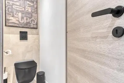 a door in a bathroom with a black toilet at 2 Chambre L - Ascenseur - Proche palais - Calme in Cannes