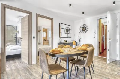 a dining room with a table and chairs and a bedroom at 2 Chambre L - Ascenseur - Proche palais - Calme in Cannes