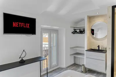 a living room with a tv on the wall at 2 Chambre L - Ascenseur - Proche palais - Calme in Cannes