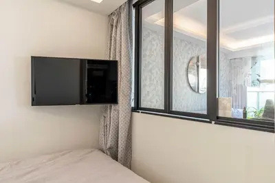 a bedroom with a tv on the wall next to a window at Superb One bedroom flat and terrace - Cannes center in Cannes