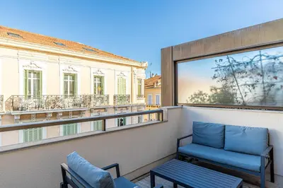 a balcony with two blue chairs and a window at Superb One bedroom flat and terrace - Cannes center in Cannes