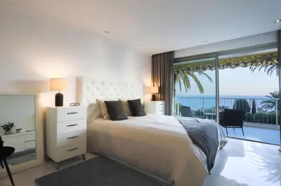 a bedroom with a large bed with a view of the ocean at Sublime appartement vue mer in Cannes