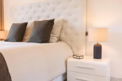 a bedroom with a white bed and a lamp on a night stand at Sublime appartement vue mer in Cannes