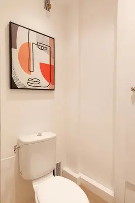 a bathroom with a toilet and a painting on the wall at Super Californie YourHostHelper in Cannes
