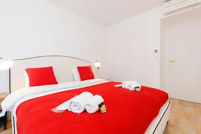 a bedroom with a red bed with towels on it at Super Californie YourHostHelper in Cannes