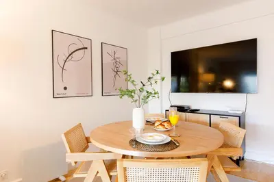 a dining room with a wooden table and chairs at Super Californie YourHostHelper in Cannes