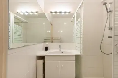 a white bathroom with a sink and a mirror at Écrin de douceur à 300m de la Croisette Calme in Cannes