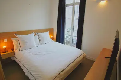 a bedroom with a large white bed with two lamps at Ref ANTIBES - Palmes d'Or Properties in Cannes
