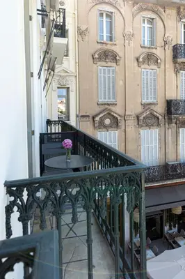 a bedroom with a bed with white sheets and a window at Ref ANTIBES - Palmes d'Or Properties in Cannes
