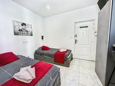 a bedroom with two beds and a door to a room at Sweet Home Marceau - 6 studios hyper centre proche de la mer et du palais in Cannes