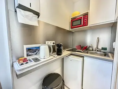 a small kitchen with a sink and a microwave at Sweet Home Marceau - 6 studios hyper centre proche de la mer et du palais in Cannes