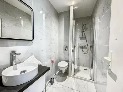 a white bathroom with a sink and a shower at Sweet Home Marceau - 6 studios hyper centre proche de la mer et du palais in Cannes