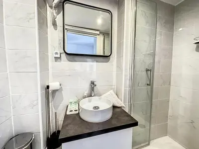 a white bathroom with a sink and a mirror at Sweet Home Marceau - 6 studios hyper centre proche de la mer et du palais in Cannes