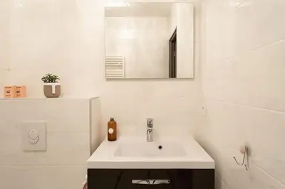 a white bathroom with a sink and a mirror at C2 - 2 BDR Montfleury - Pool, Garage, Terrace & AC in Cannes