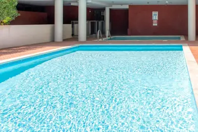 a large swimming pool with blue water in a building at C2 - 2 BDR Montfleury - Pool, Garage, Terrace & AC in Cannes