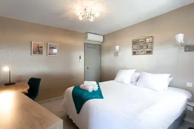 a bedroom with a large white bed and a table at C2 - 2 BDR Montfleury - Pool, Garage, Terrace & AC in Cannes