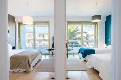 a hotel room with two beds and a balcony at PANORAMIC SEA VIEW - 2-Br Apartment Mouré Rouge in Cannes