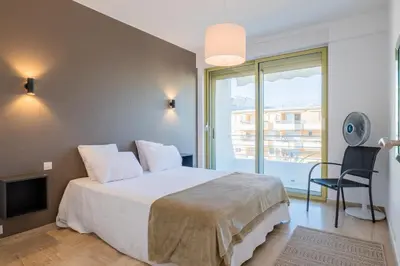 a bedroom with a large bed and a balcony at PANORAMIC SEA VIEW - 2-Br Apartment Mouré Rouge in Cannes
