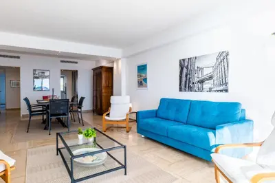 a living room with a blue couch and a table at PANORAMIC SEA VIEW - 2-Br Apartment Mouré Rouge in Cannes