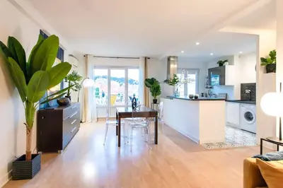 a living room with a table and a kitchen at C5 - 2 BDR Blvd Carnot - 10 min Palais - AC & Terrace Sea View in Cannes