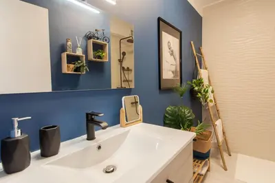 a bathroom with a white sink and a blue wall at C5 - 2 BDR Blvd Carnot - 10 min Palais - AC & Terrace Sea View in Cannes