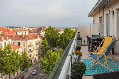 a balcony with a table and chairs on a building at C5 - 2 BDR Blvd Carnot - 10 min Palais - AC & Terrace Sea View in Cannes