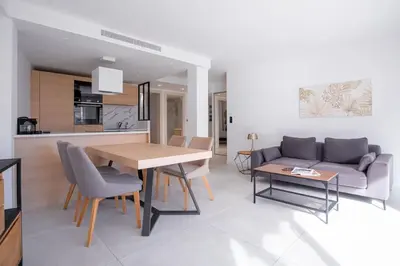 a living room with a table and a couch at Amazing Apartment With Private Terrace & Full Air Conditioning - Walk To The Beach, La Croisette! - Latour Maubourg 18 by Halldis in Cannes