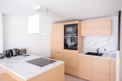 a kitchen with wooden cabinets and a counter top at Amazing Apartment With Private Terrace & Full Air Conditioning - Walk To The Beach, La Croisette! - Latour Maubourg 18 by Halldis in Cannes
