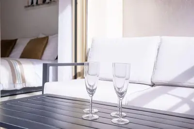 two wine glasses sitting on a table next to a couch at Amazing Apartment With Private Terrace & Full Air Conditioning - Walk To The Beach, La Croisette! - Latour Maubourg 18 by Halldis in Cannes