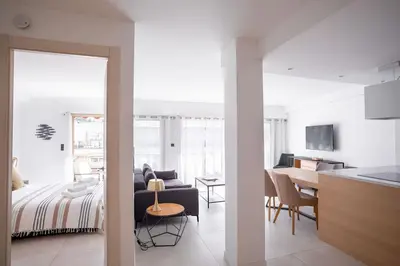 a kitchen and a living room with a bed and a table at Amazing Apartment With Private Terrace & Full Air Conditioning - Walk To The Beach, La Croisette! - Latour Maubourg 18 by Halldis in Cannes