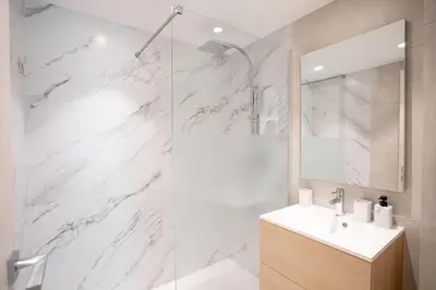 a white bathroom with a shower and a sink at Amazing Apartment With Private Terrace & Full Air Conditioning - Walk To The Beach, La Croisette! - Latour Maubourg 18 by Halldis in Cannes